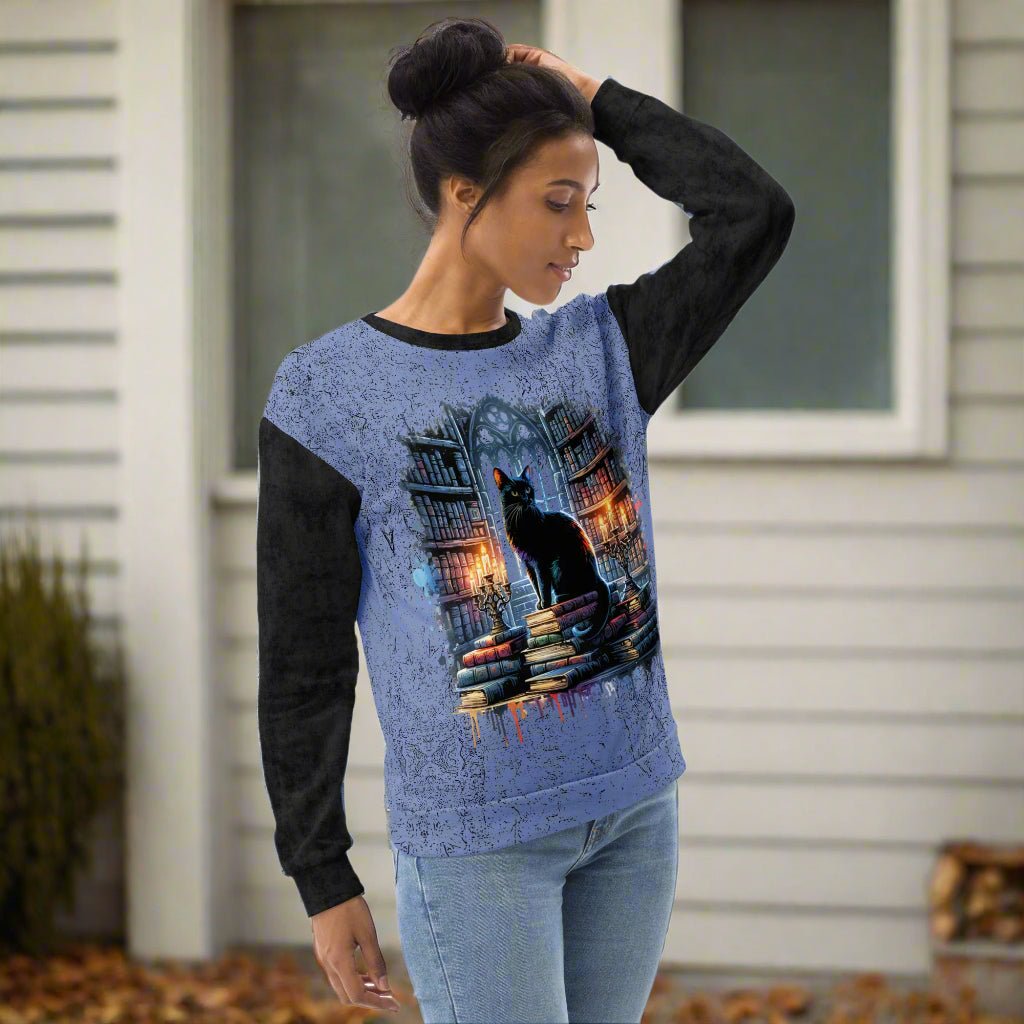Woman wearing a blue and black sweatshirt with a cat design on a white background
