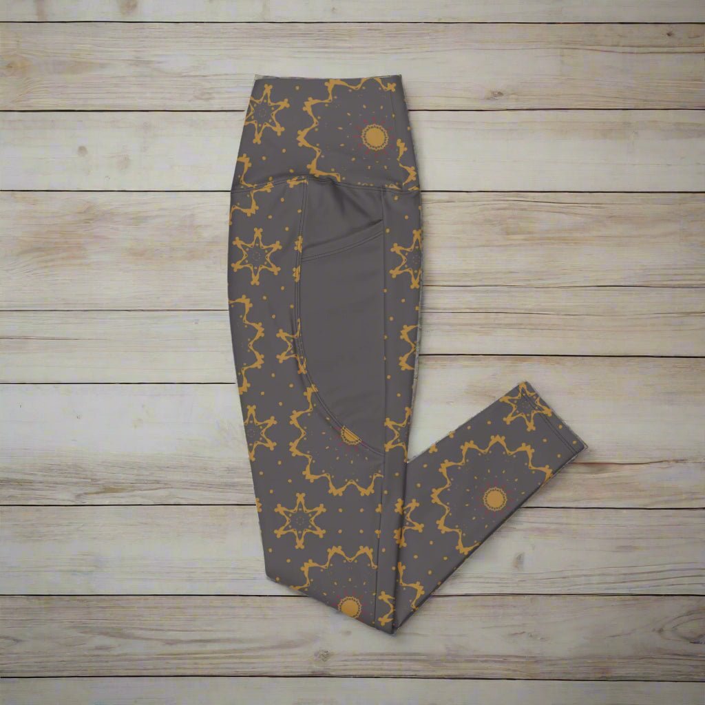 Dark gray leggings with gold star pattern on a wood background
