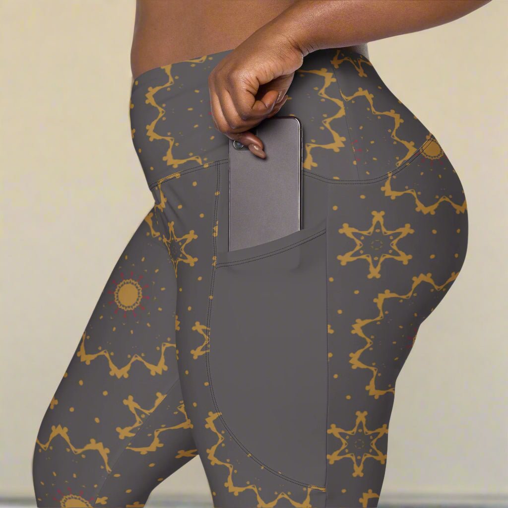 Gray leggings with gold star pattern worn by a person, showing a pocket.
