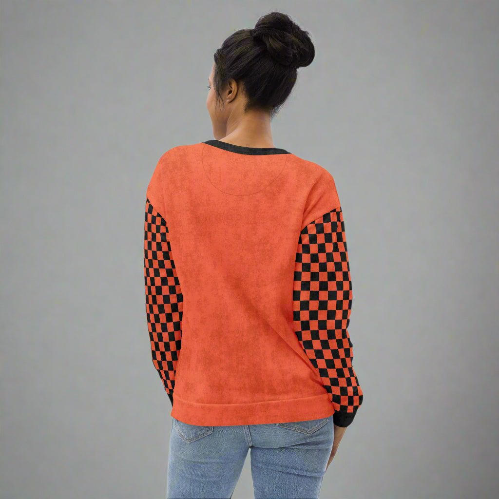 Person wearing an orange sweatshirt with checkered sleeves on a white background