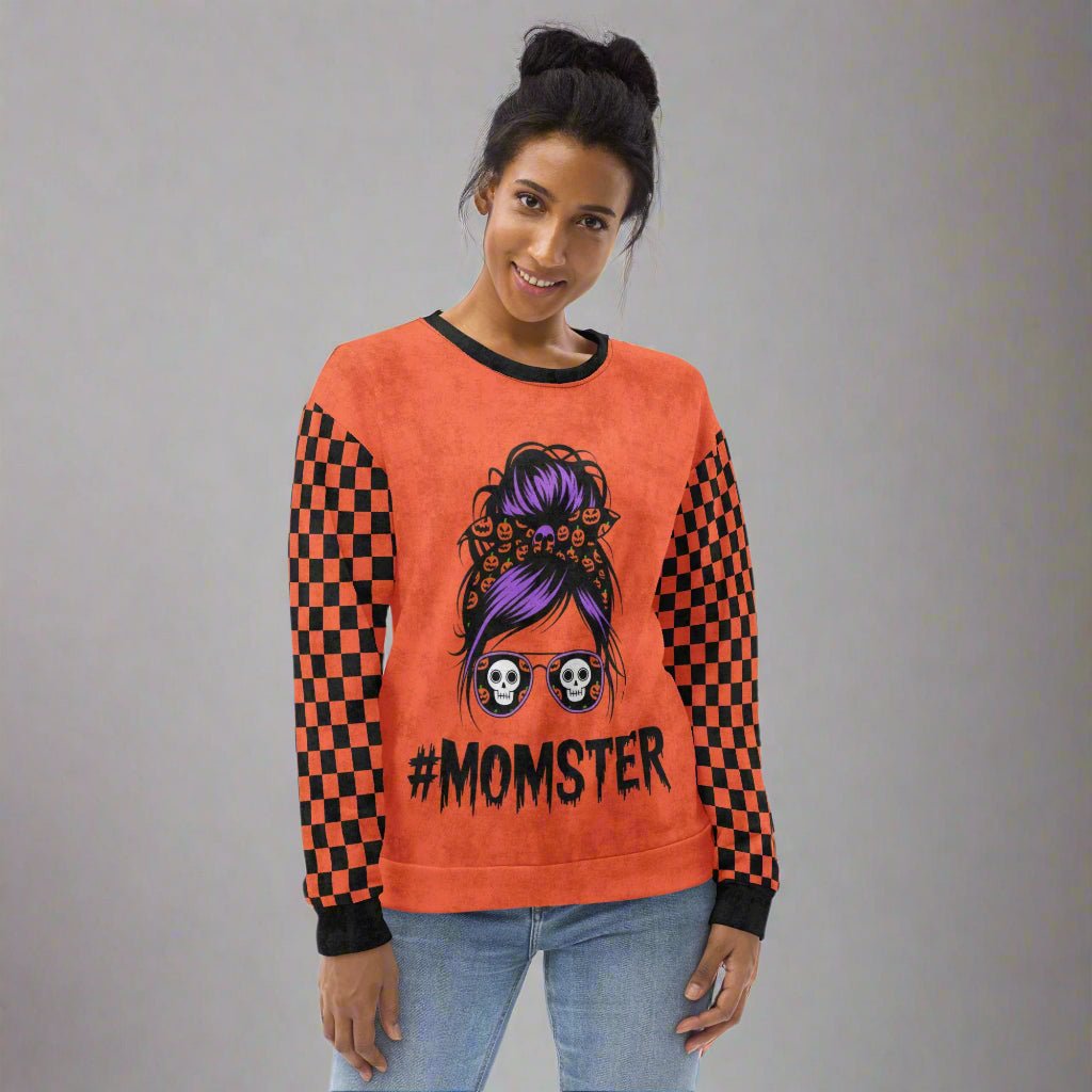 Person wearing an orange sweatshirt with a '#Momster' design on a white background