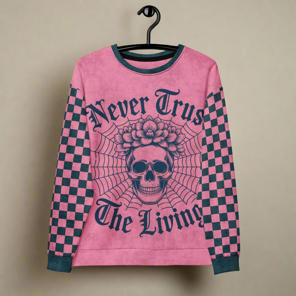 Pink sweater with skull design and text on a hanger
