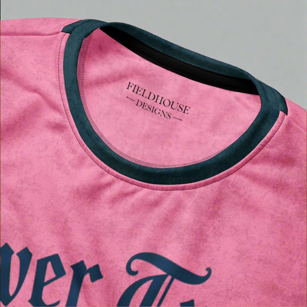 Pink shirt with black trim and 'Fieldhouse Designs' branding