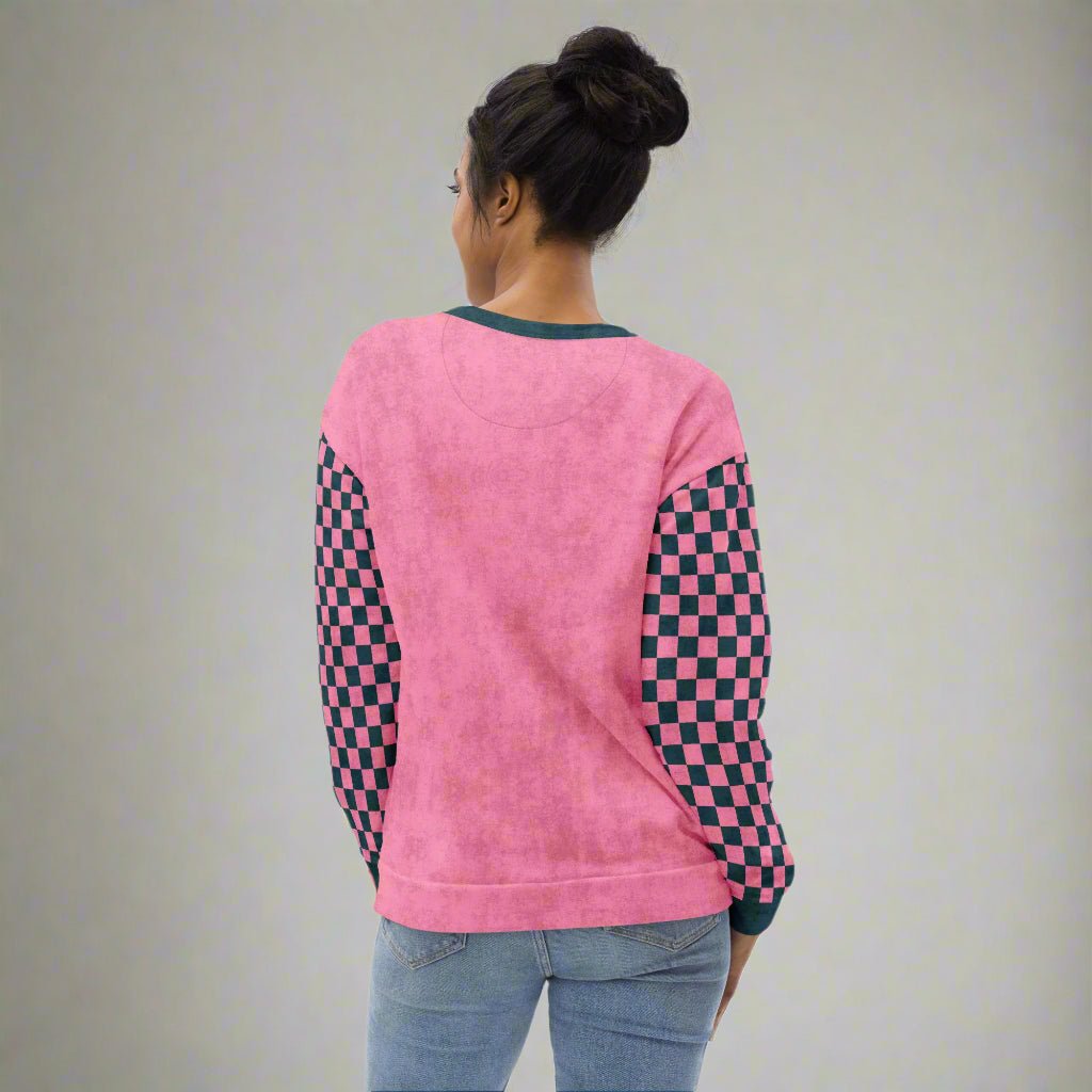 Person wearing a pink sweatshirt with checkered sleeves on a white background
