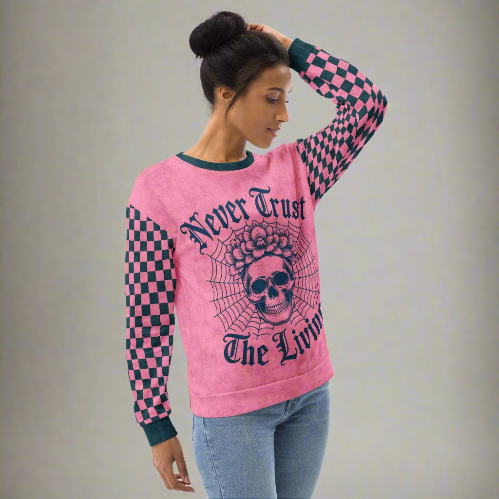 Woman wearing a pink sweatshirt with a skull design and text on a beige background