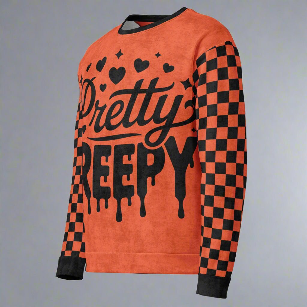 Orange sweatshirt with 'Pretty Creepy' text and black checkered sleeves on a neutral background