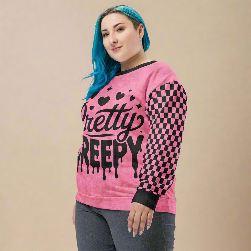 Person wearing a pink sweater with black text and checkered sleeves on a beige background