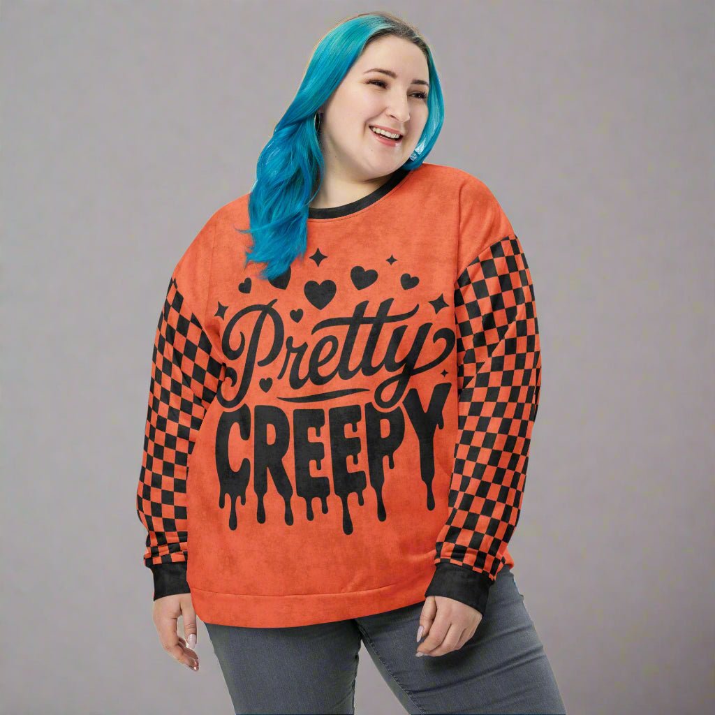 Person wearing an orange and black 'Pretty Creepy' sweatshirt with checkered pattern.