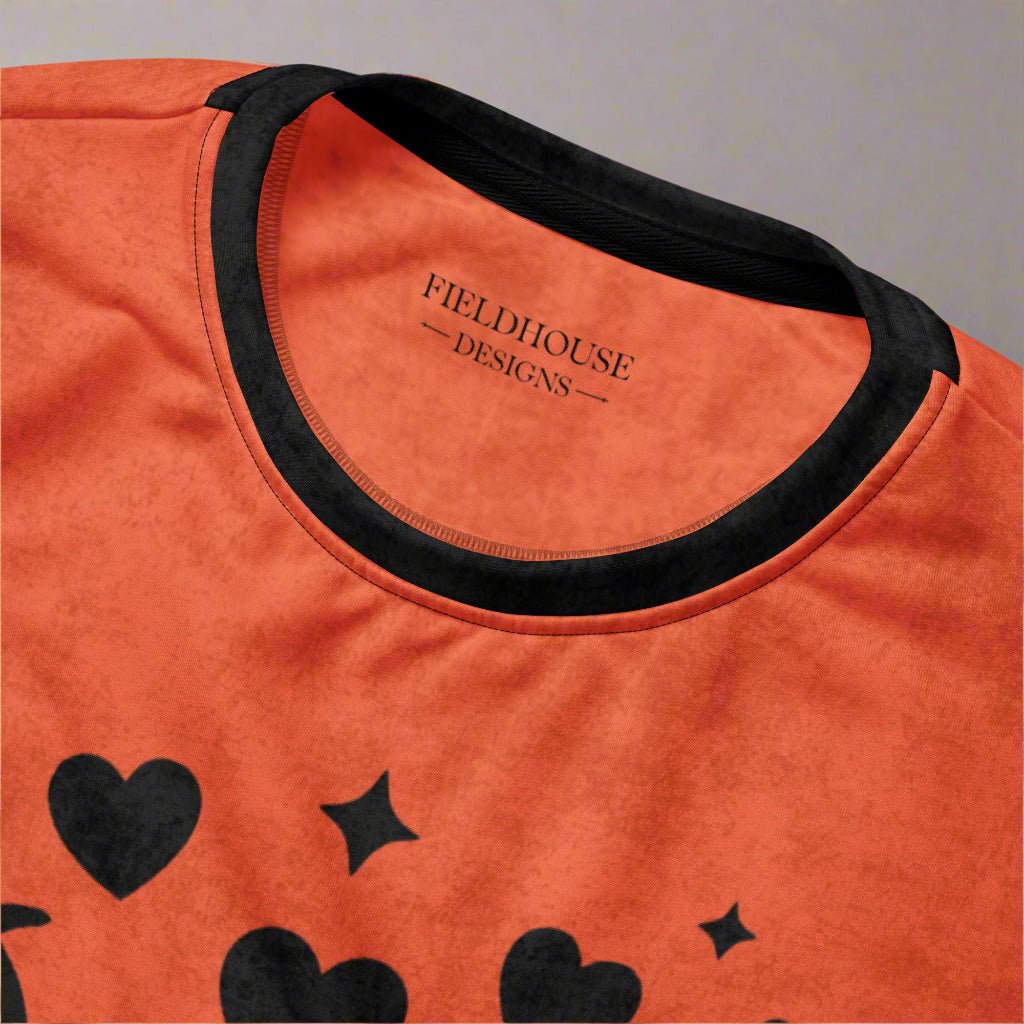 Orange shirt with black hearts and stars and 'Fieldhouse Designs' branding.