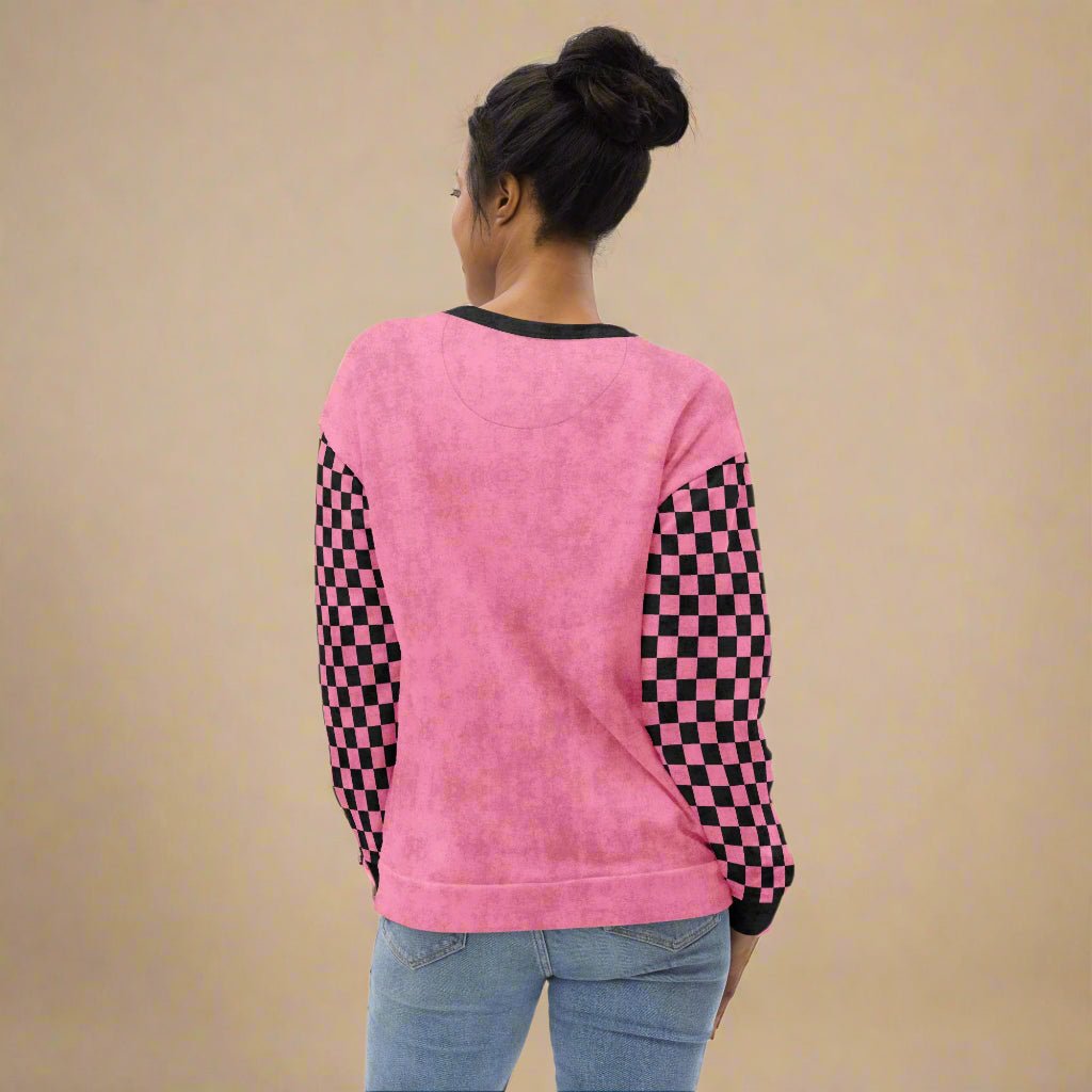 Person wearing a pink sweatshirt with checkered sleeves on a beige background