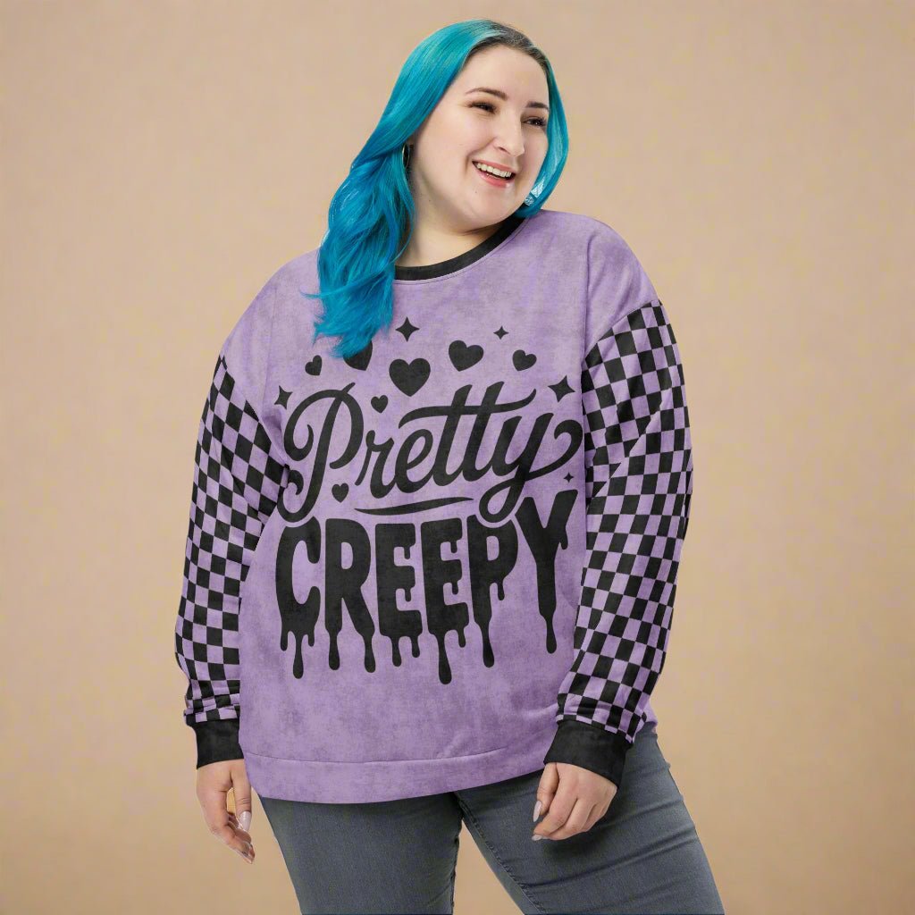 Person wearing a purple sweatshirt with 'Pretty Creepy' text and checkered sleeves on a neutral background