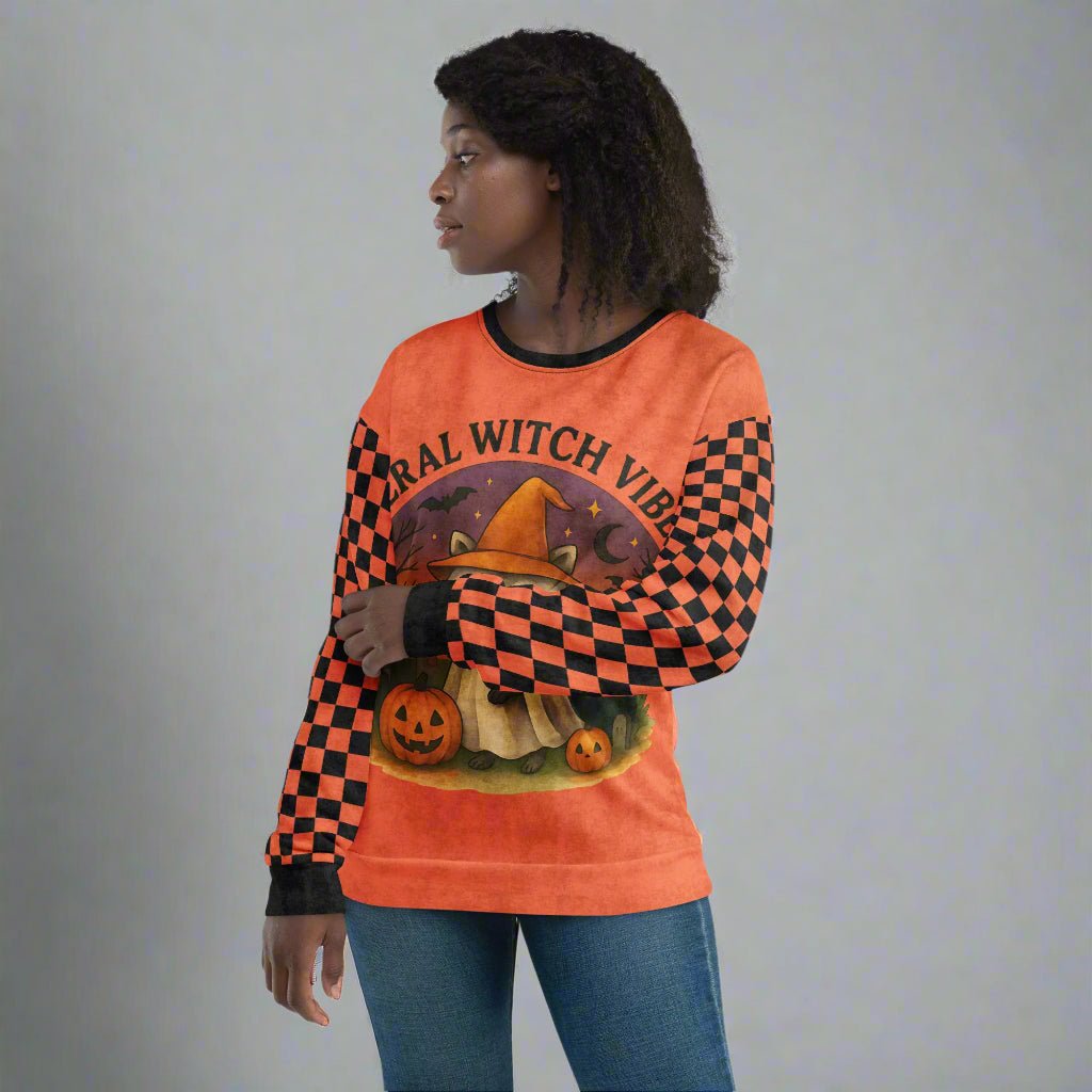 Person wearing an orange sweatshirt with Halloween-themed graphics and text.