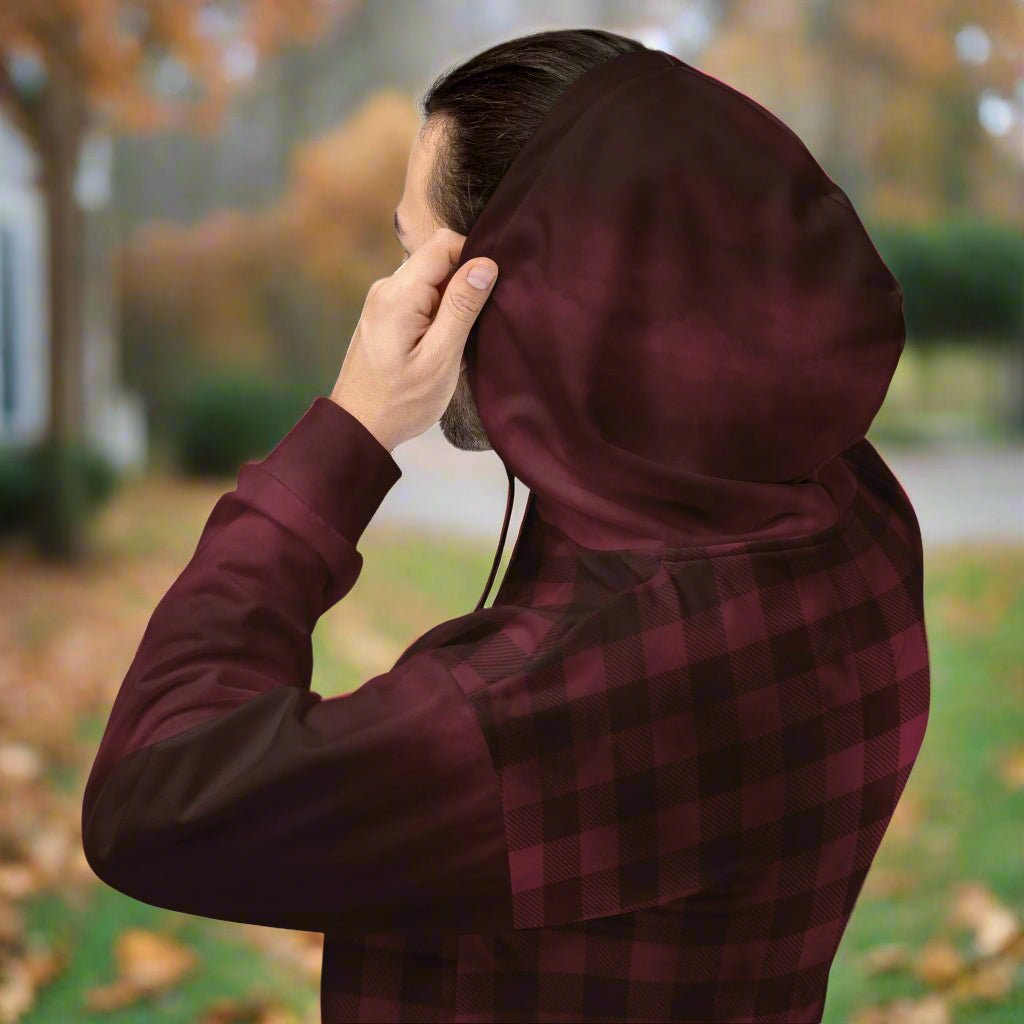 Person wearing a burgundy hoodie with a plaid pattern outdoors