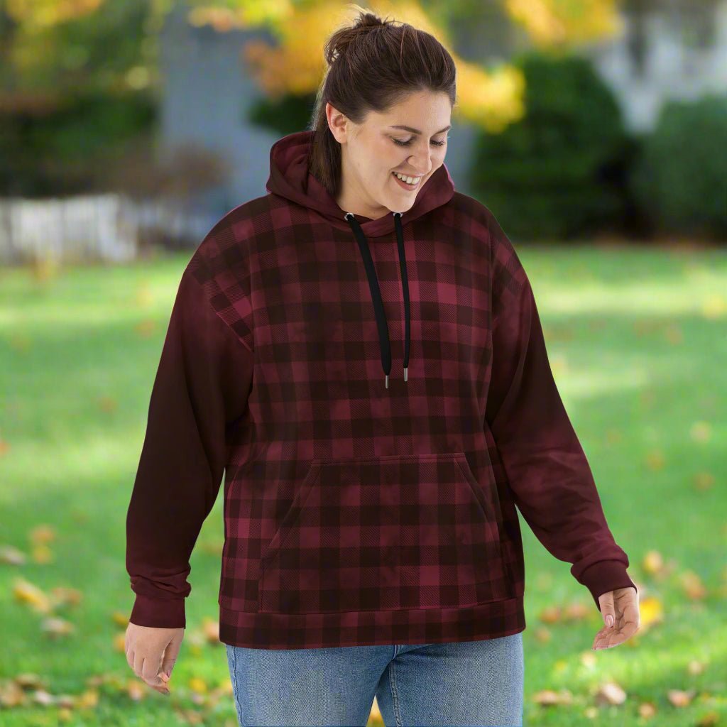 Woman wearing a burgundy and black plaid hoodie outdoors