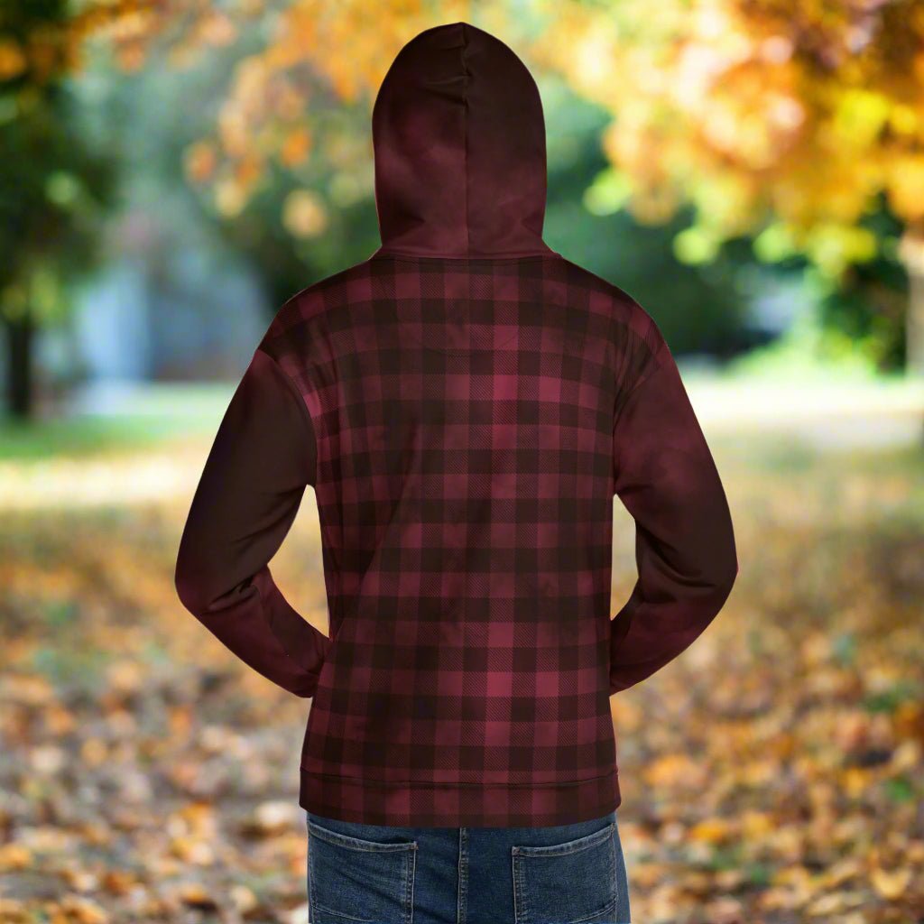 Person wearing a burgundy plaid hoodie with a blurred autumn background