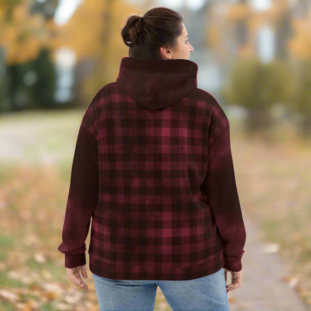 Person wearing a burgundy and black plaid hoodie outdoors