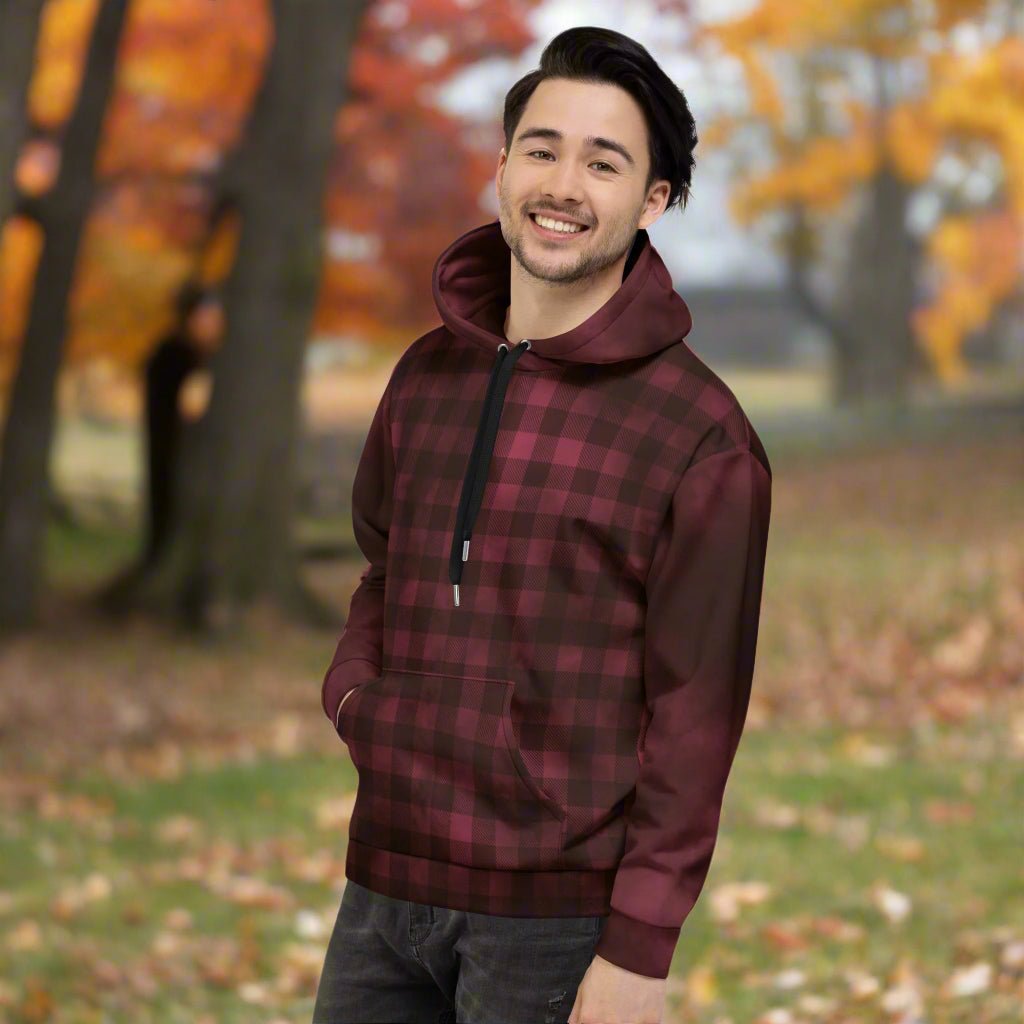 Man wearing a burgundy and black plaid hoodie outdoors
