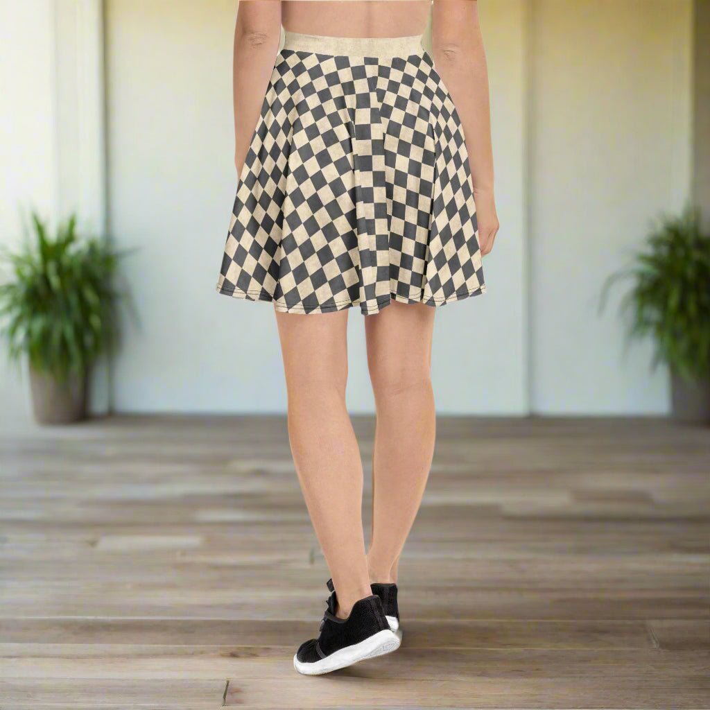 Person wearing a gray and ivory checkered skirt on a wooden floor.