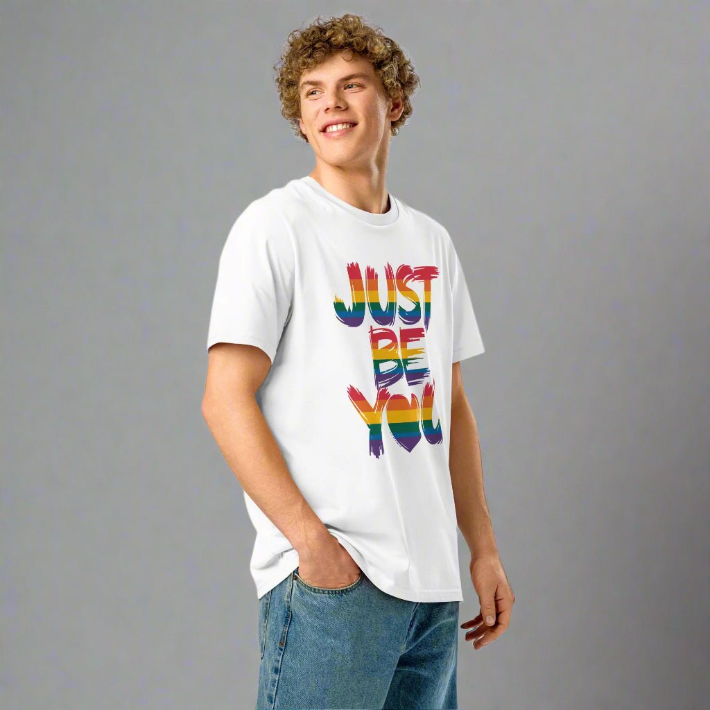 Person wearing a white t-shirt with 'JUST BE YOU' in rainbow letters on a white background