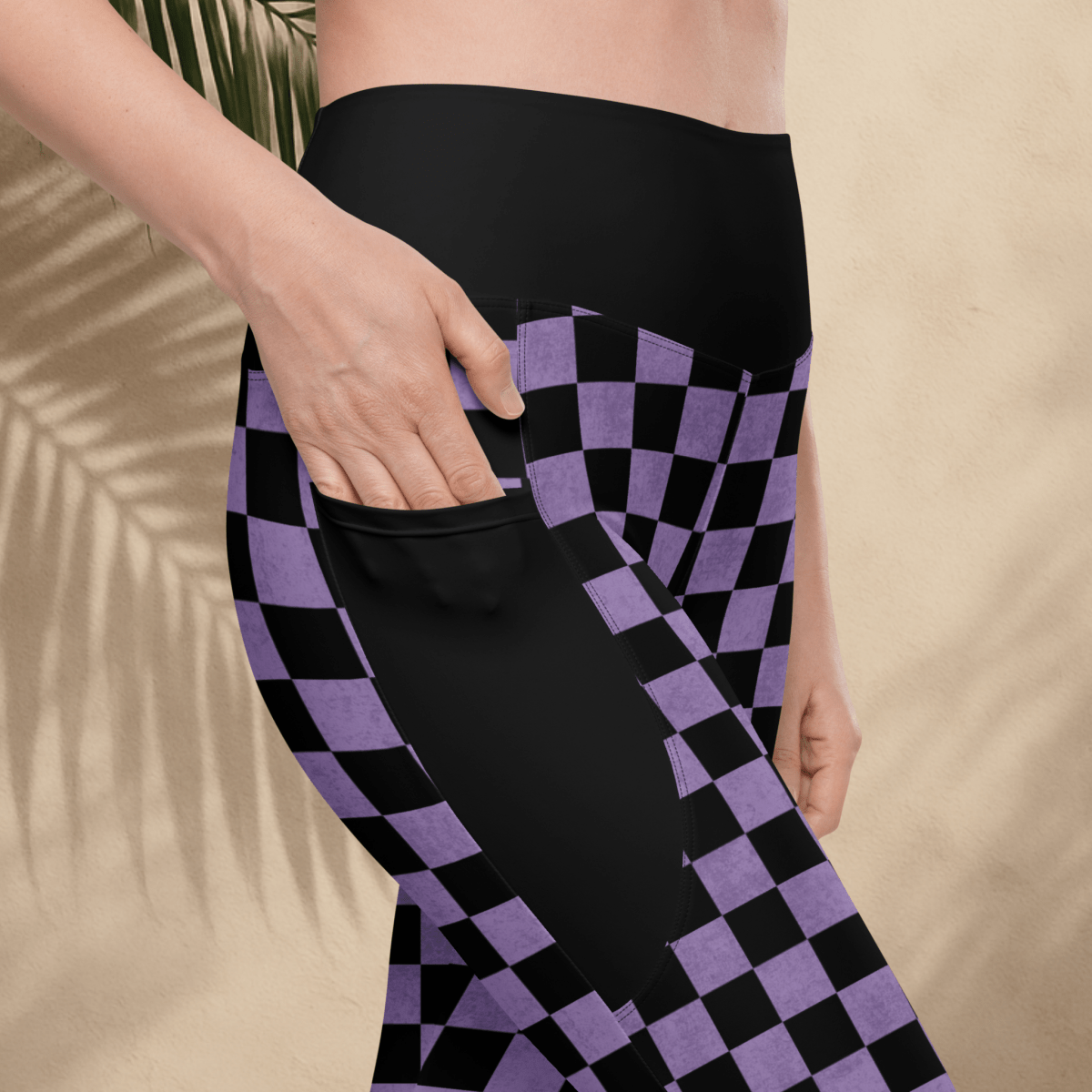 Person wearing black and purple checkered pants with a beige background