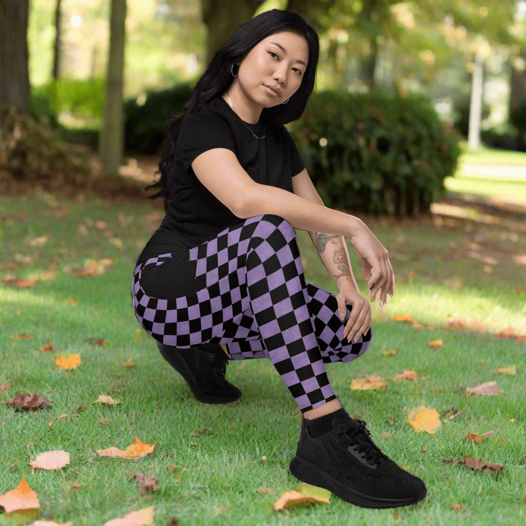 Person wearing black t-shirt and purple checkered pants outdoors