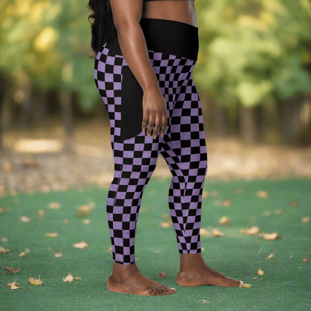 Person wearing black and purple checkered leggings outdoors on a green surface with blurred trees in the background.