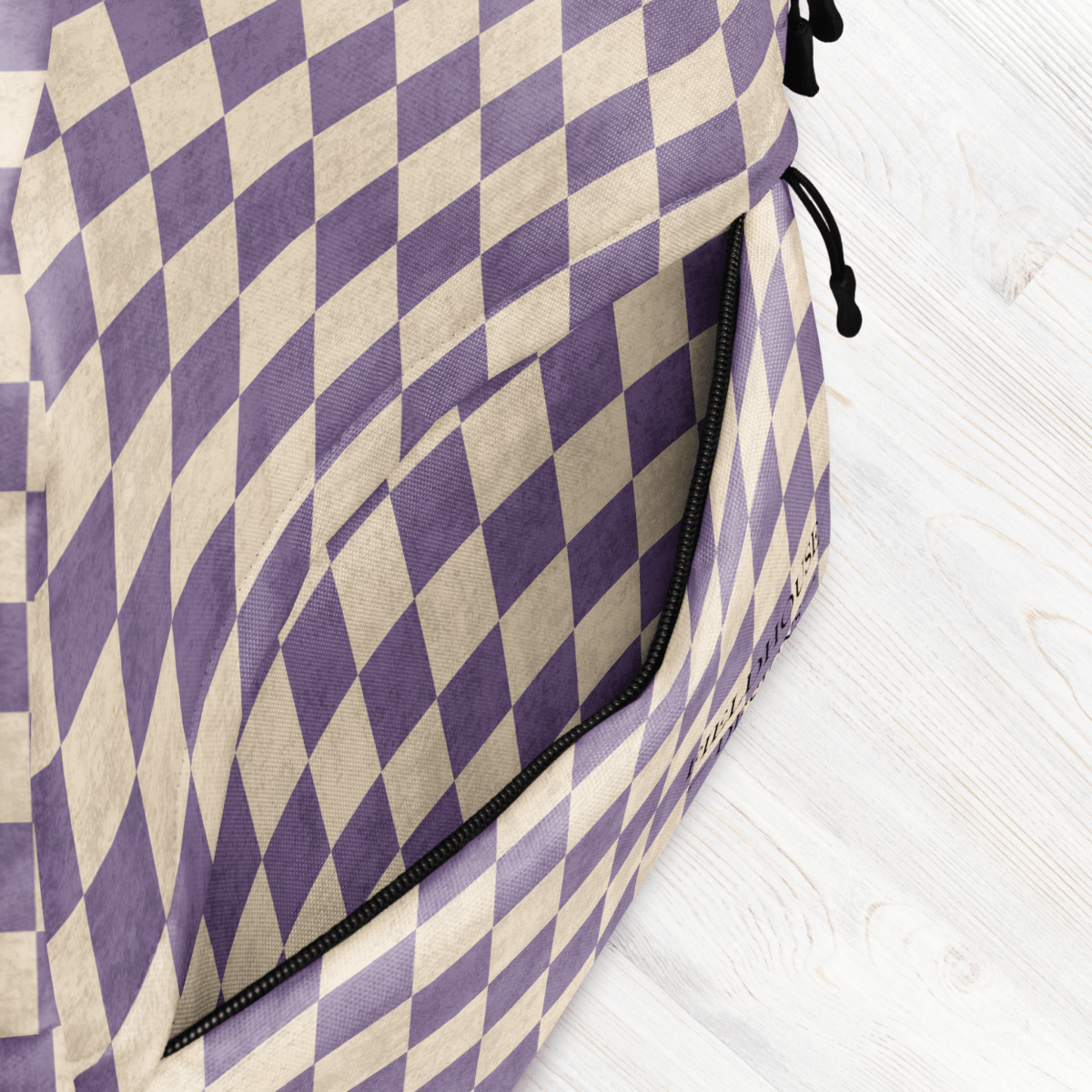 Purple and beige checkered bag on a light wooden surface
