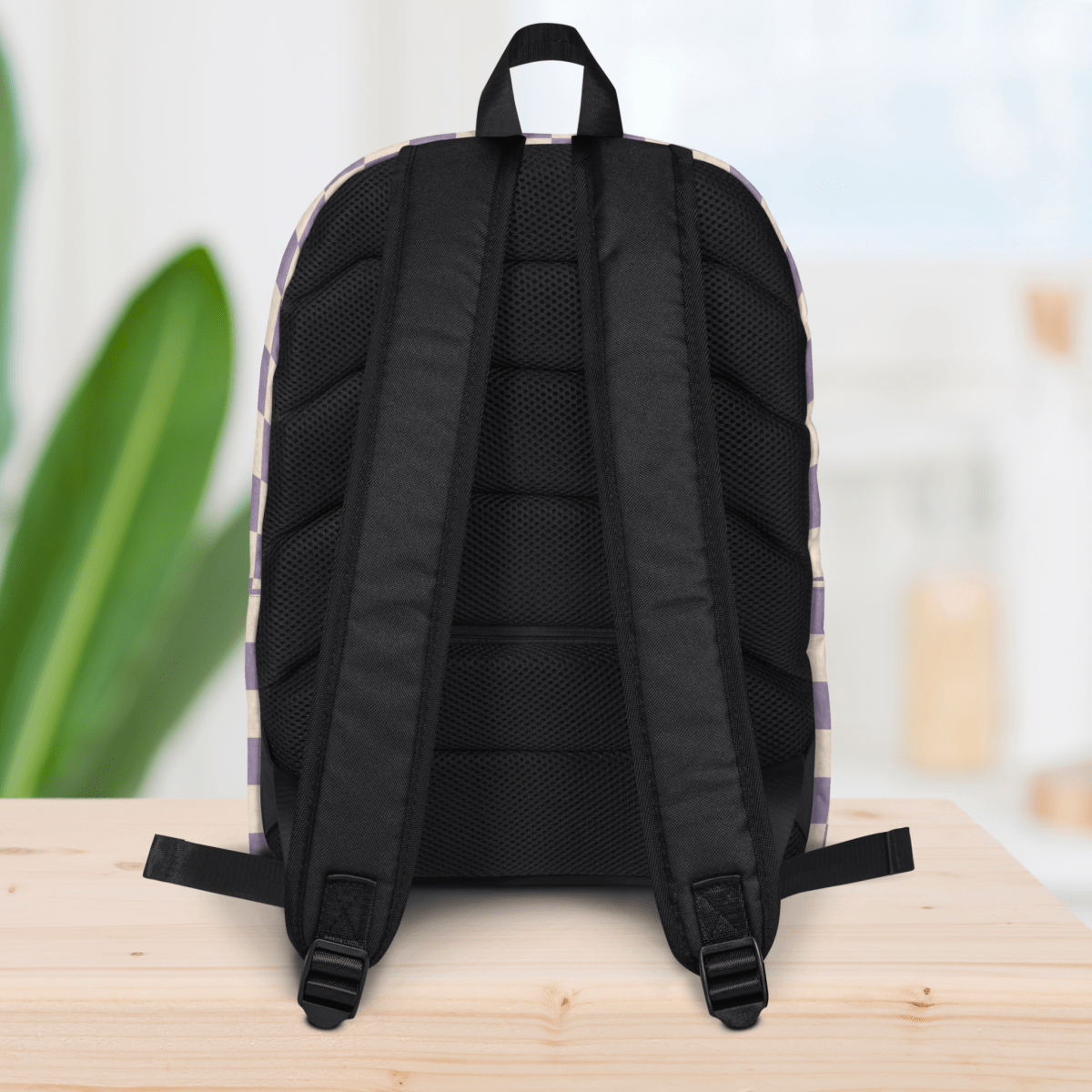 Backside of a backpack on a wooden surface with a blurred background