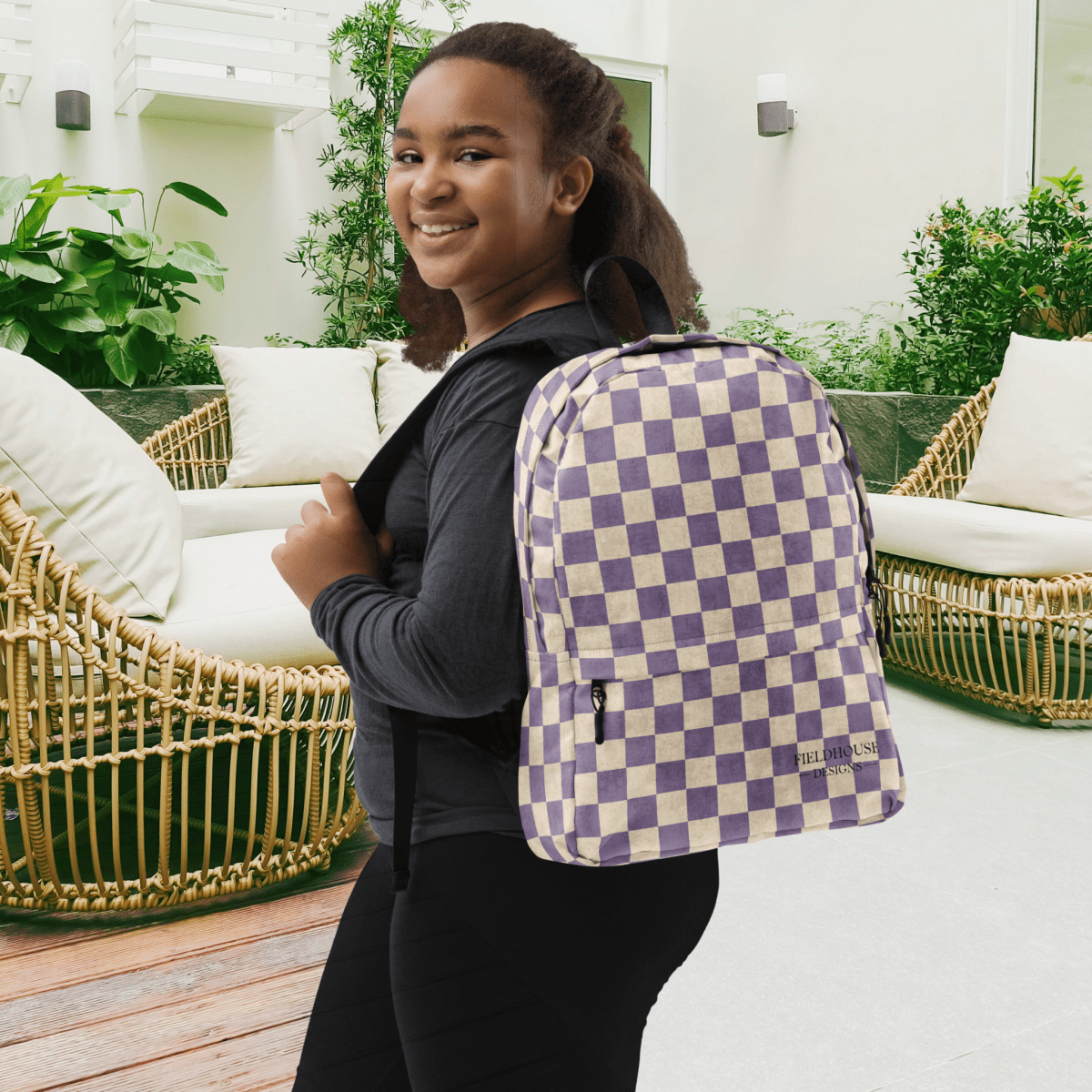 Person wearing a purple and white checkered backpack in an outdoor setting