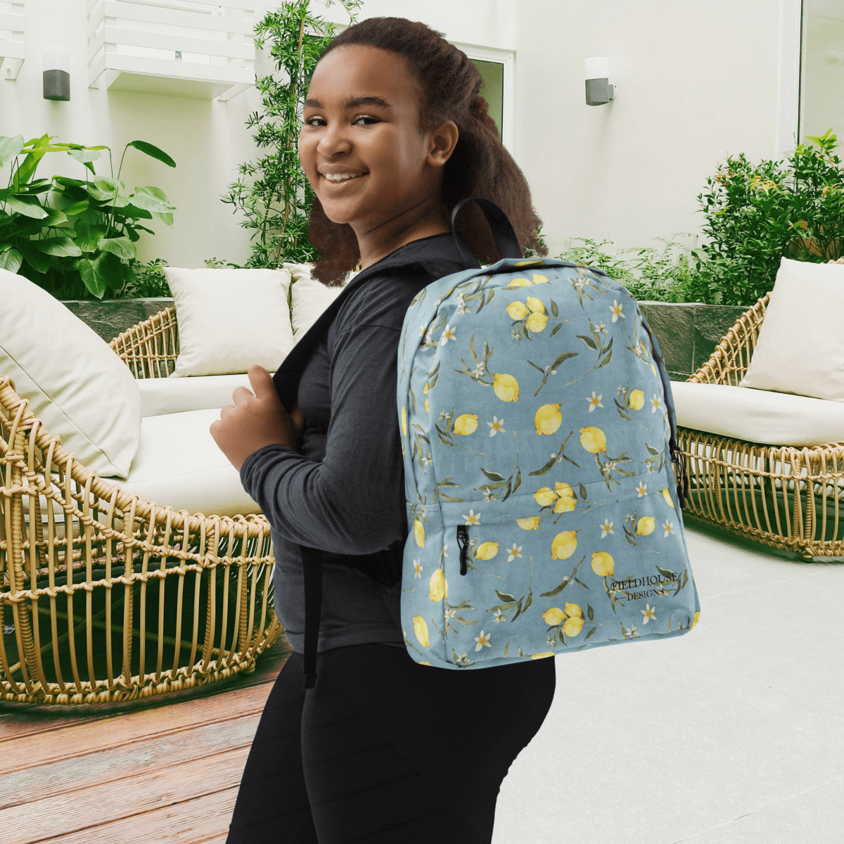 Person wearing a blue lemon-patterned backpack outdoors