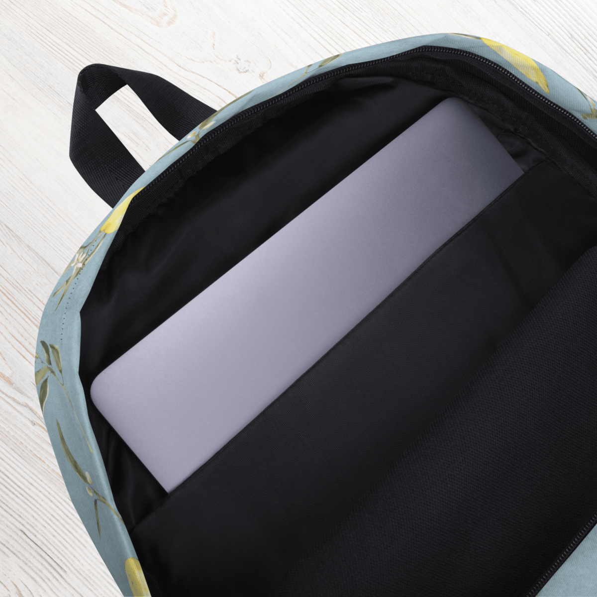 Backpack with a laptop inside on a light wooden surface