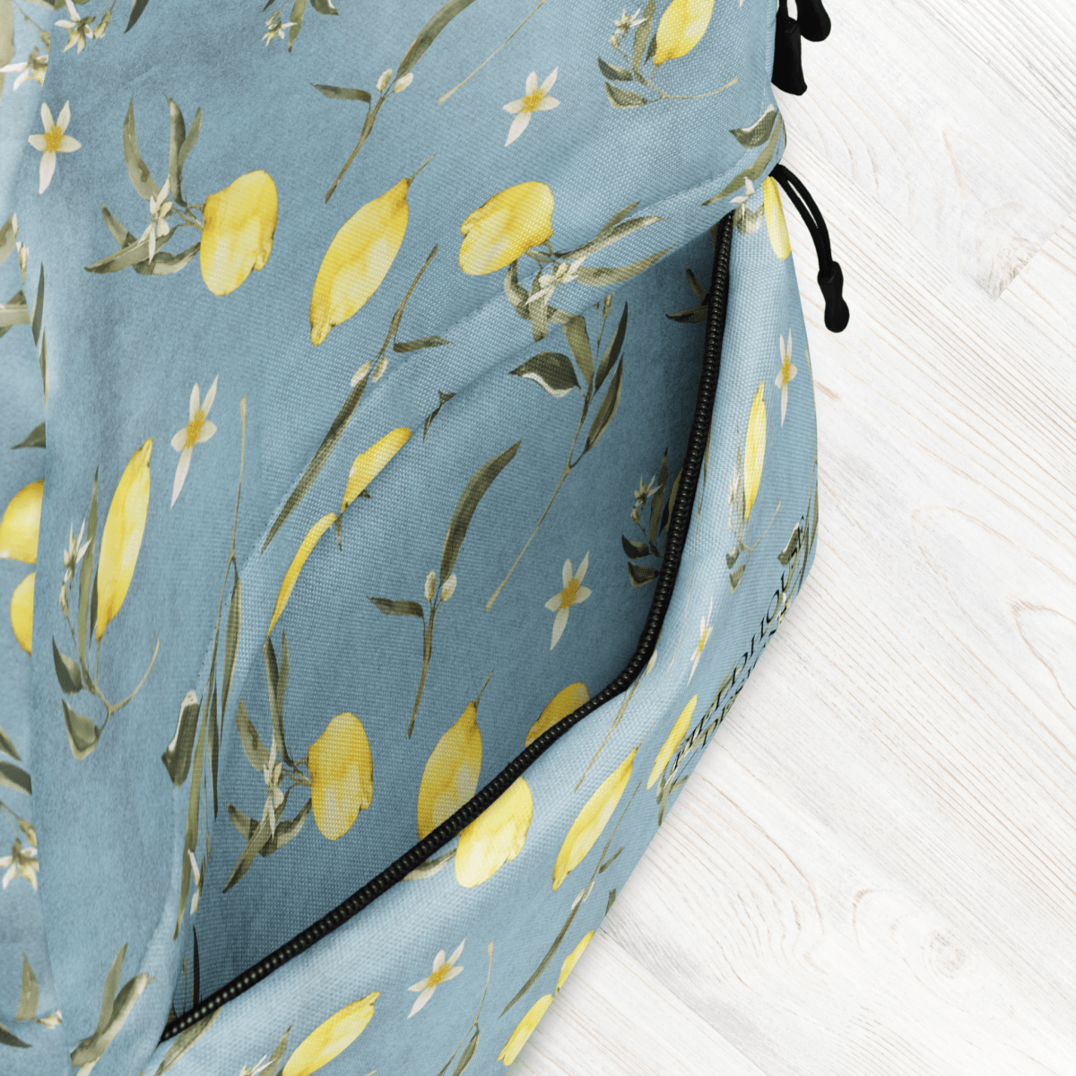 Blue bag with lemon and flower pattern on a light wooden surface