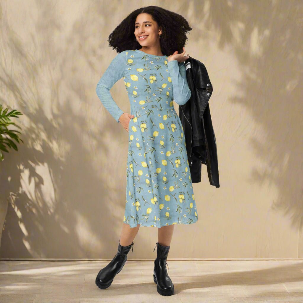 Woman wearing a blue floral dress with black boots against a beige wall.