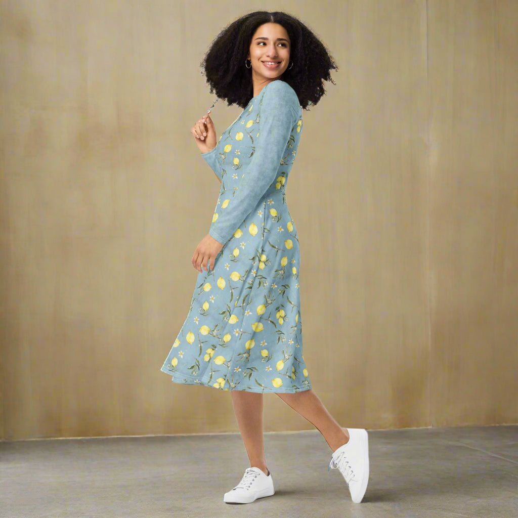 Woman wearing a blue dress with lemon floral pattern on a neutral background