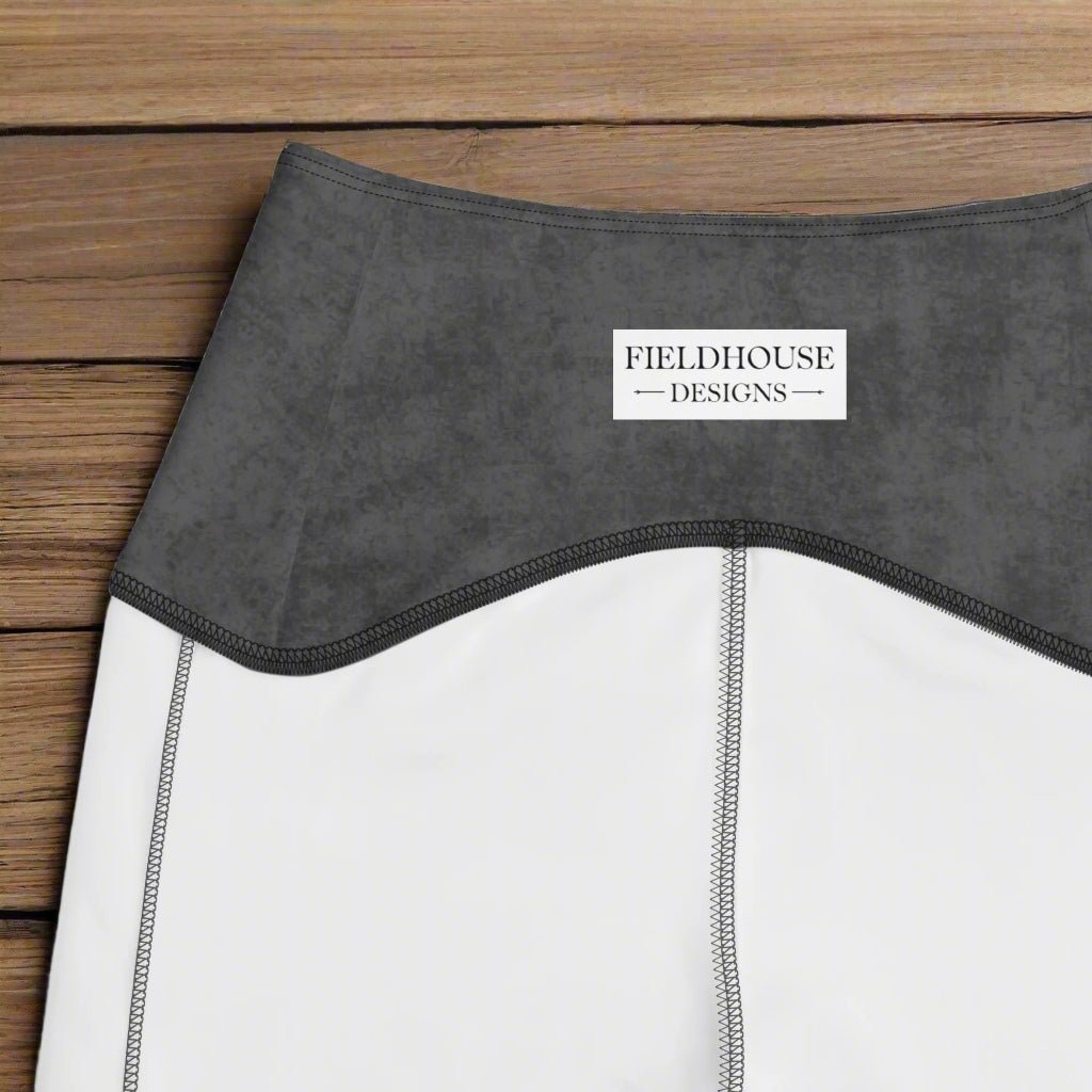 Close-up of a garment with 'Fieldhouse Designs' label on a wooden surface