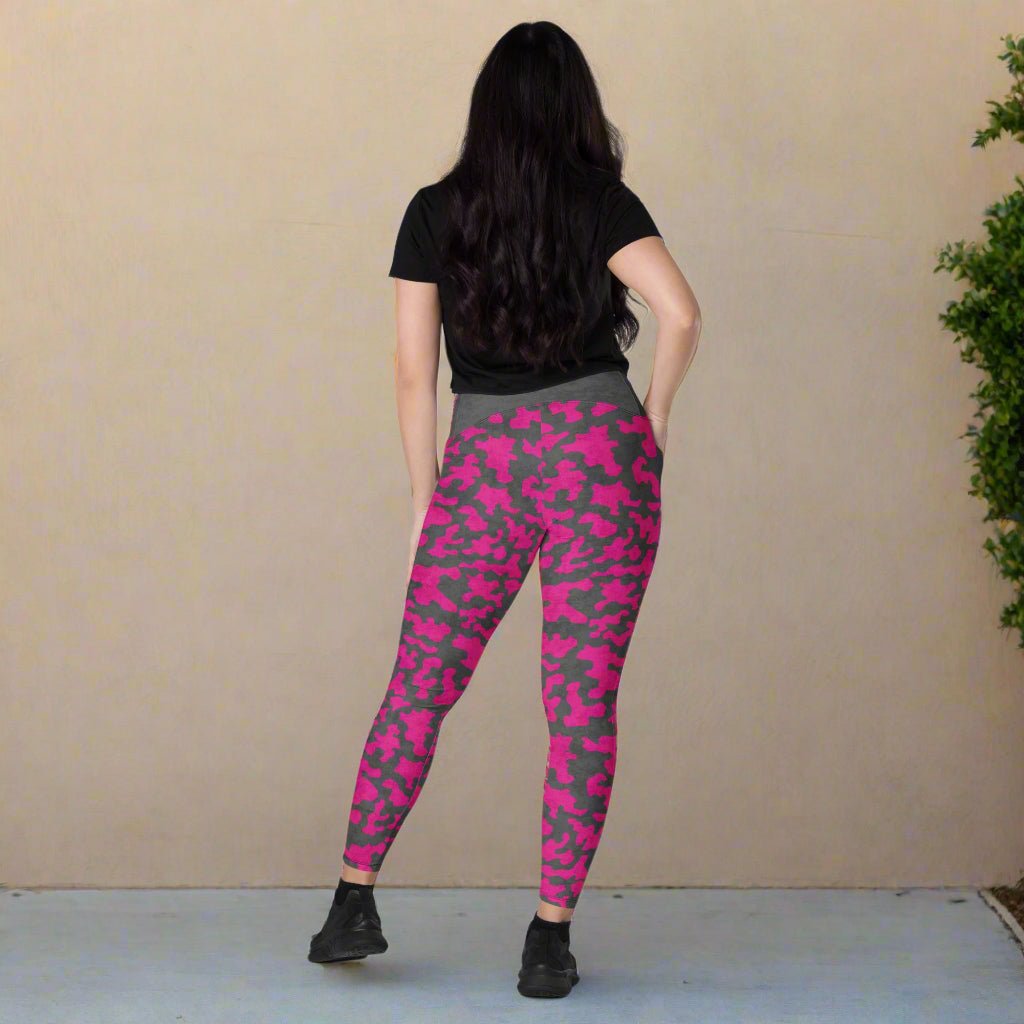 Person wearing pink and gray camouflage leggings against a beige wall.