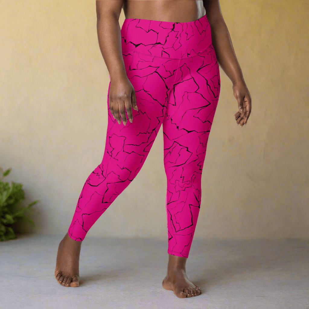 Person wearing bright pink leggings with black abstract patterns against a neutral background