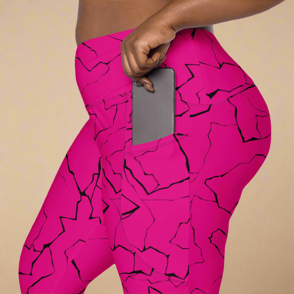 Person wearing bright pink leggings with black abstract patterns on a beige background
