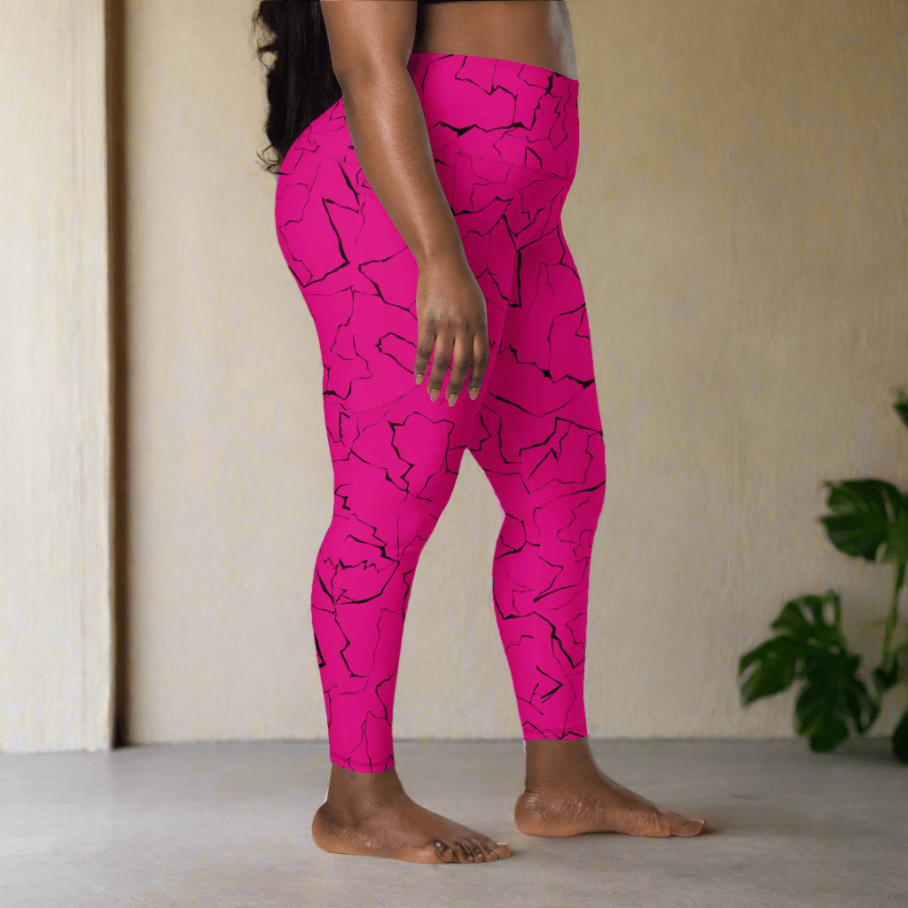 Person wearing bright pink leggings with black abstract pattern in a minimal indoor setting.