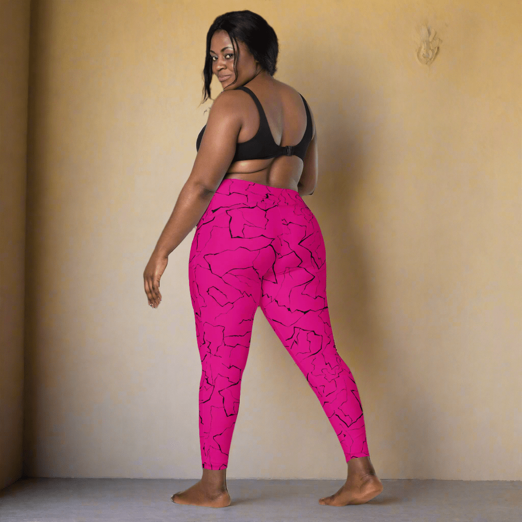 Woman wearing bright pink leggings with a black pattern on a neutral background