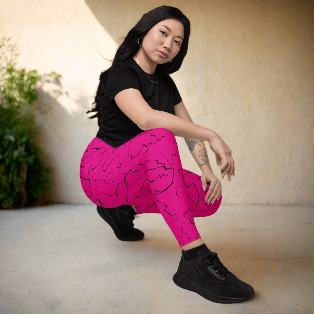 Person wearing pink leggings with black patterns and a black top, sitting on the floor.