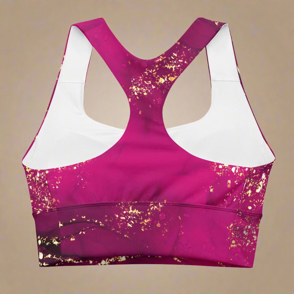 Pink sports bra with gold glitter pattern on a beige background