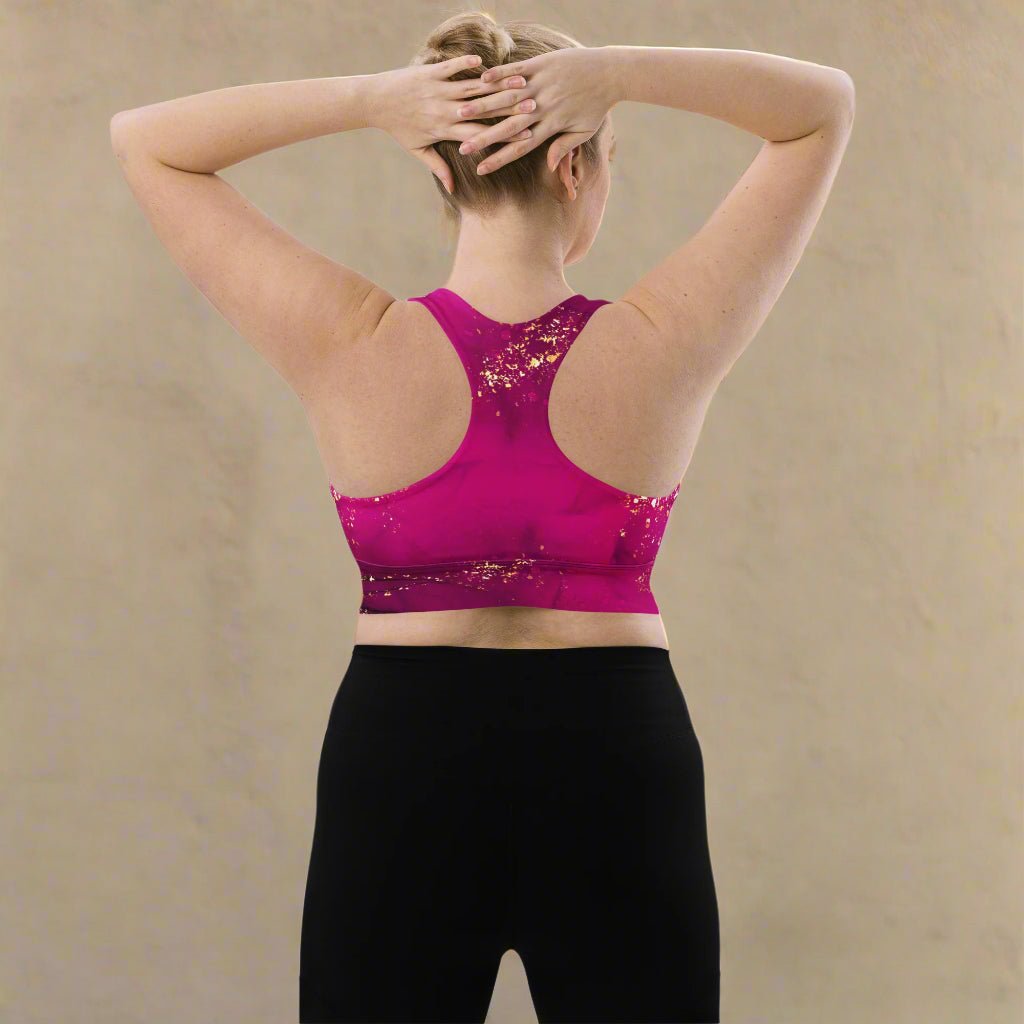Person wearing a pink sports bra and black leggings against a beige background