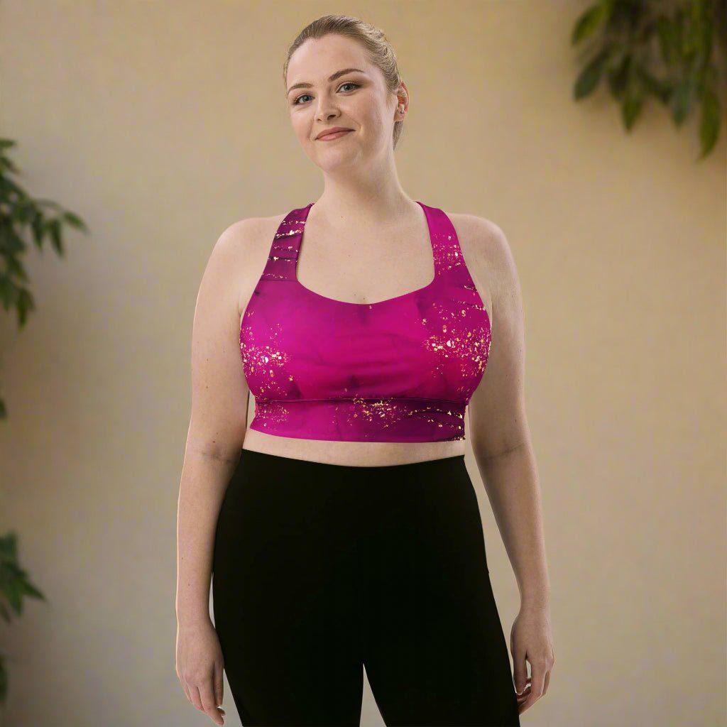 Woman wearing a pink sports bra and black leggings against a beige background