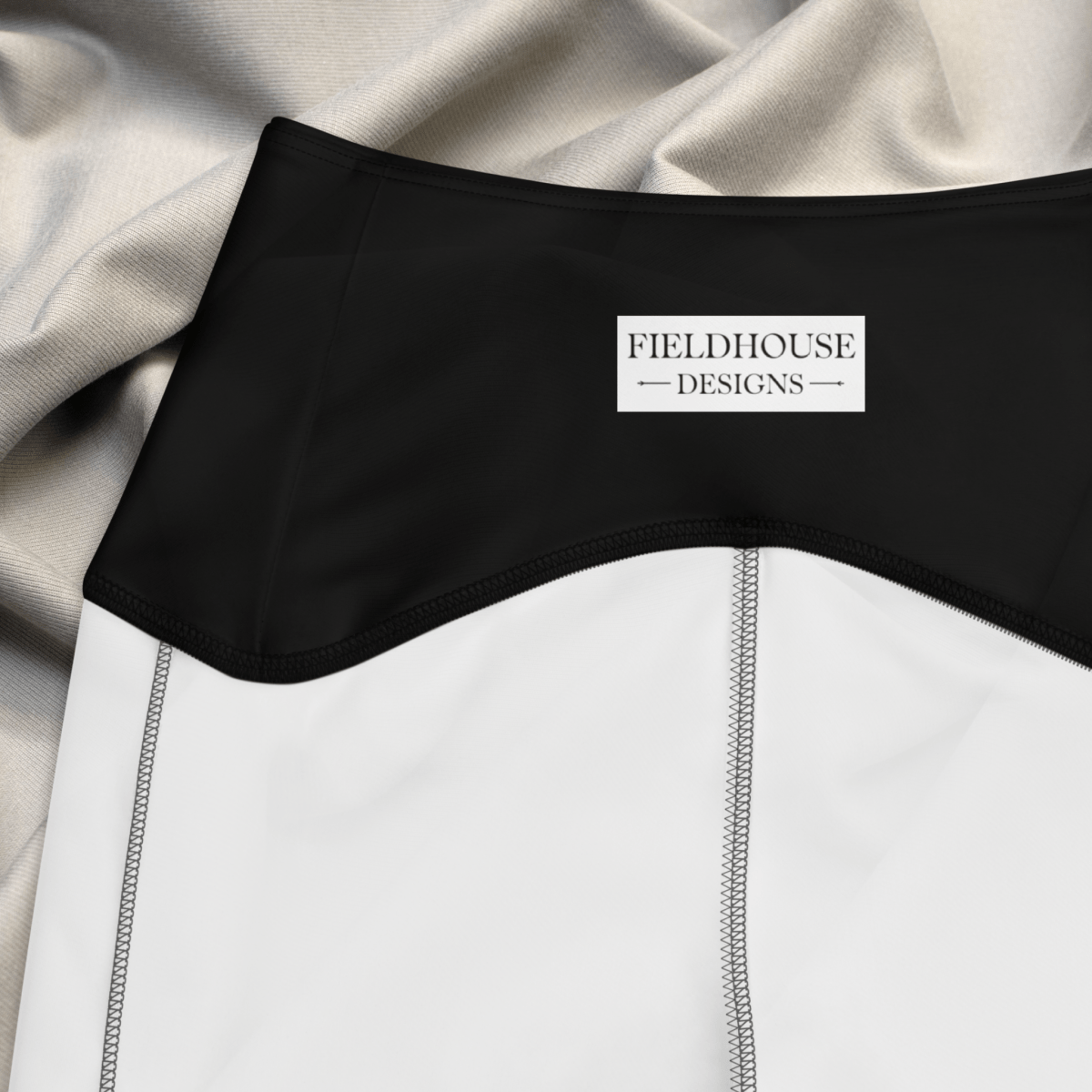 Black waistband with 'Fieldhouse Designs' label on gray fabric background