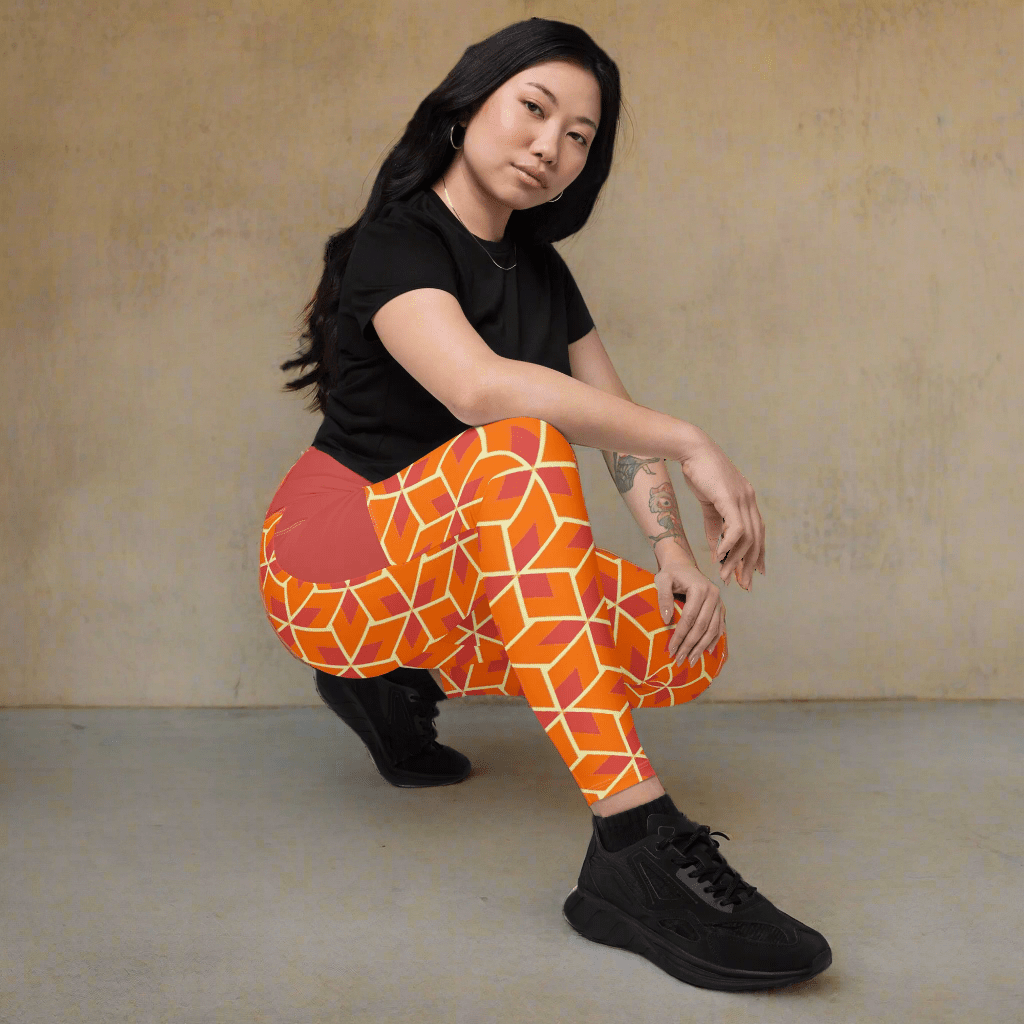 Person wearing orange geometric leggings and black shoes on a beige background