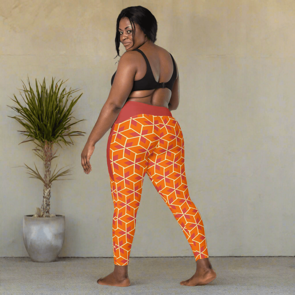 Woman wearing orange geometric patterned leggings on a neutral background