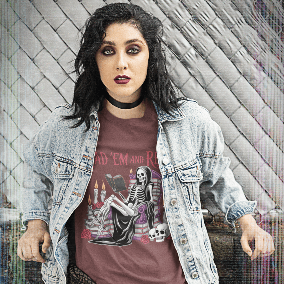 Person wearing a graphic t-shirt with a skeleton design against a textured wall.