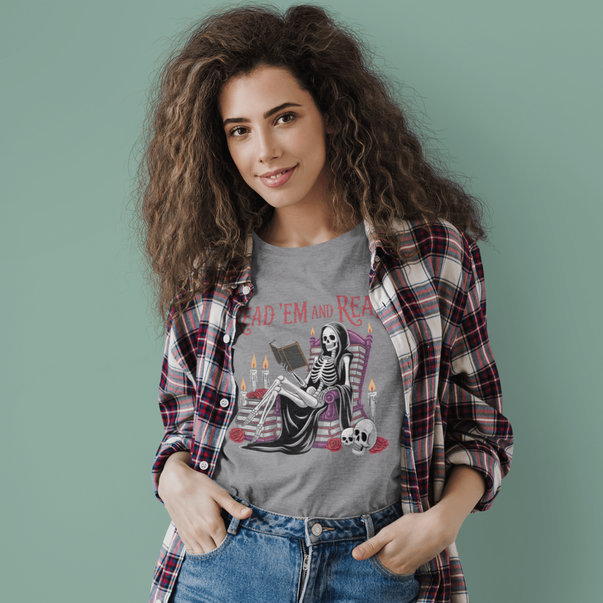 Woman wearing a graphic t-shirt with a skeleton design and plaid shirt on a green background