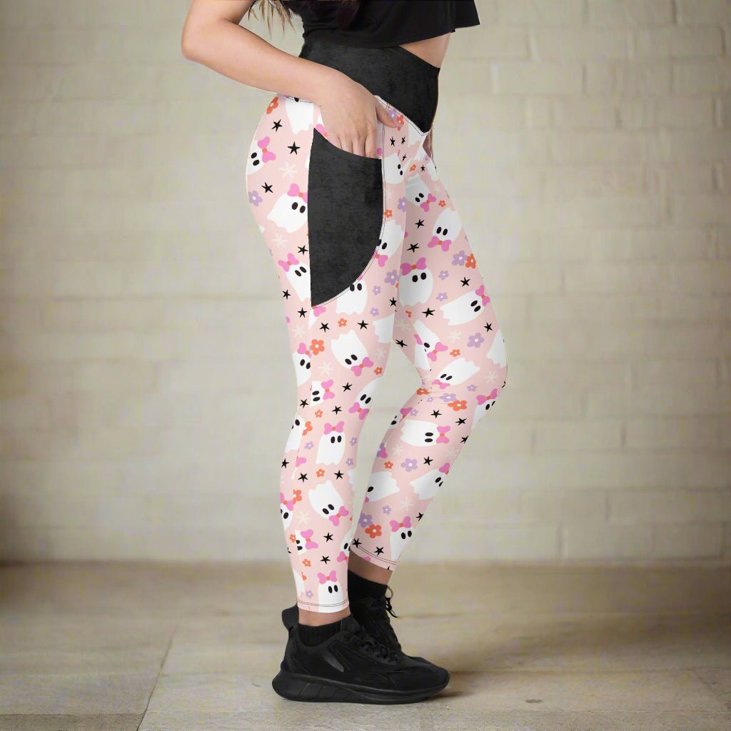 Leggings with a floral and ghost print worn by a person on a neutral background